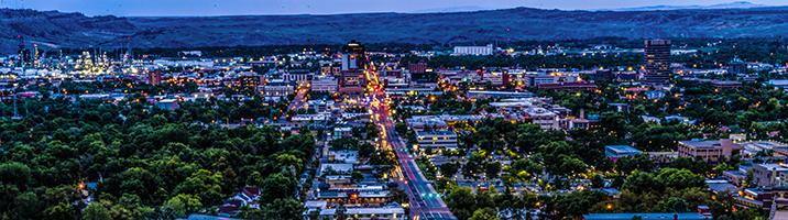 city scape of low rise residential and trees with warm lights in Montana