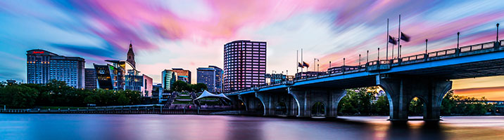 bright purple blue and white sky with bridge and river