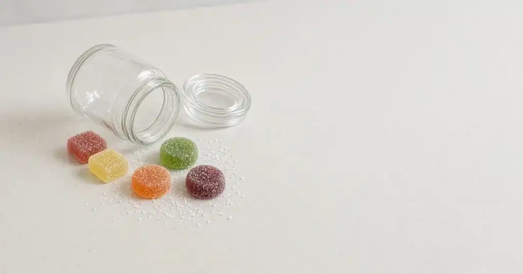 Cannabis gummies spilled from a jar on a kitchen counter