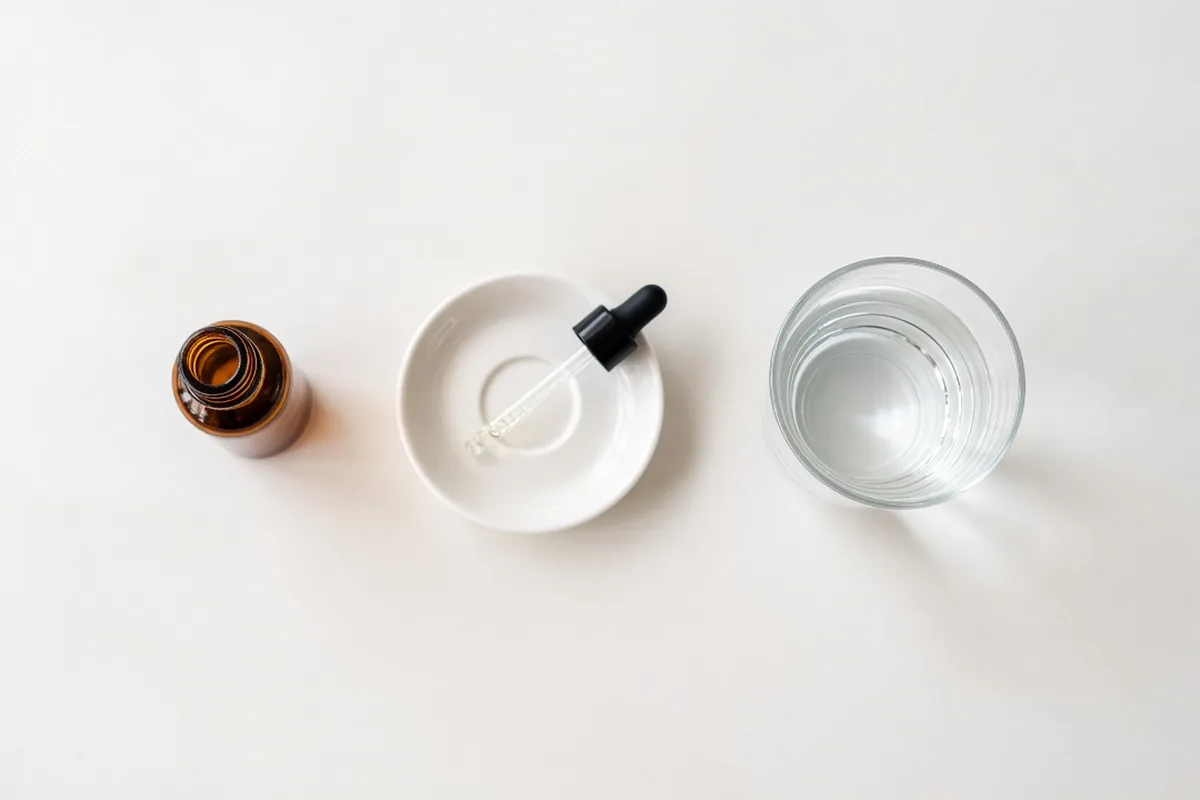 CBD oil dropper next to a water glass