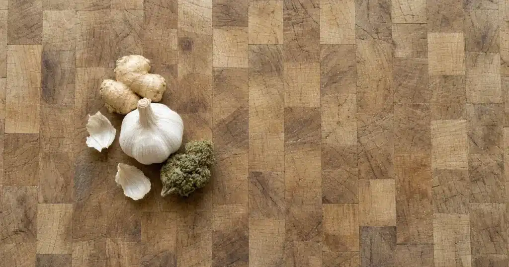Garlic, ginger root and a cannabis bud on a cutting board