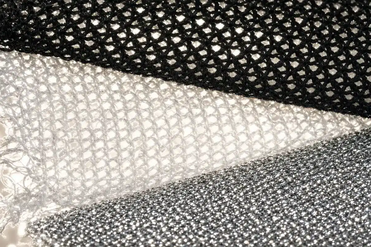Close-up of black, white and aluminized shade cloth weaves in sunlight.